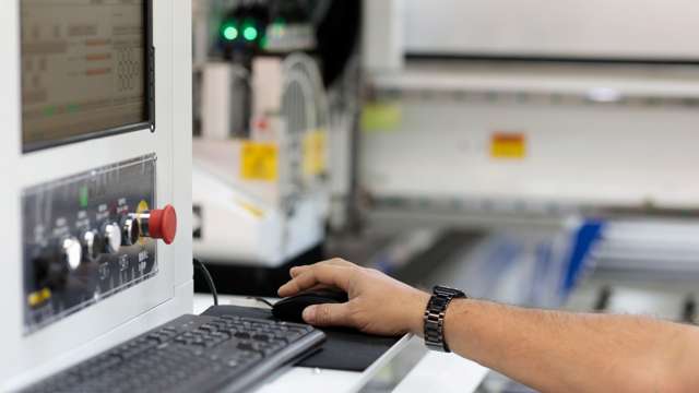 Hand steuert Computermaus bei Maschinensteuerung