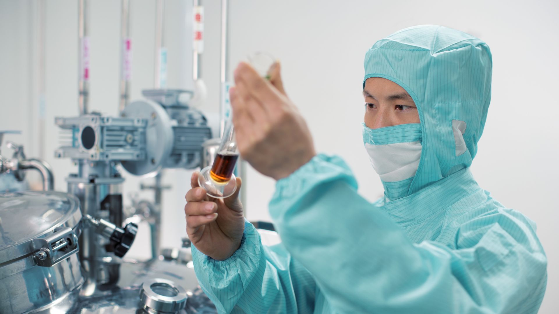 pharma worker inspects flask